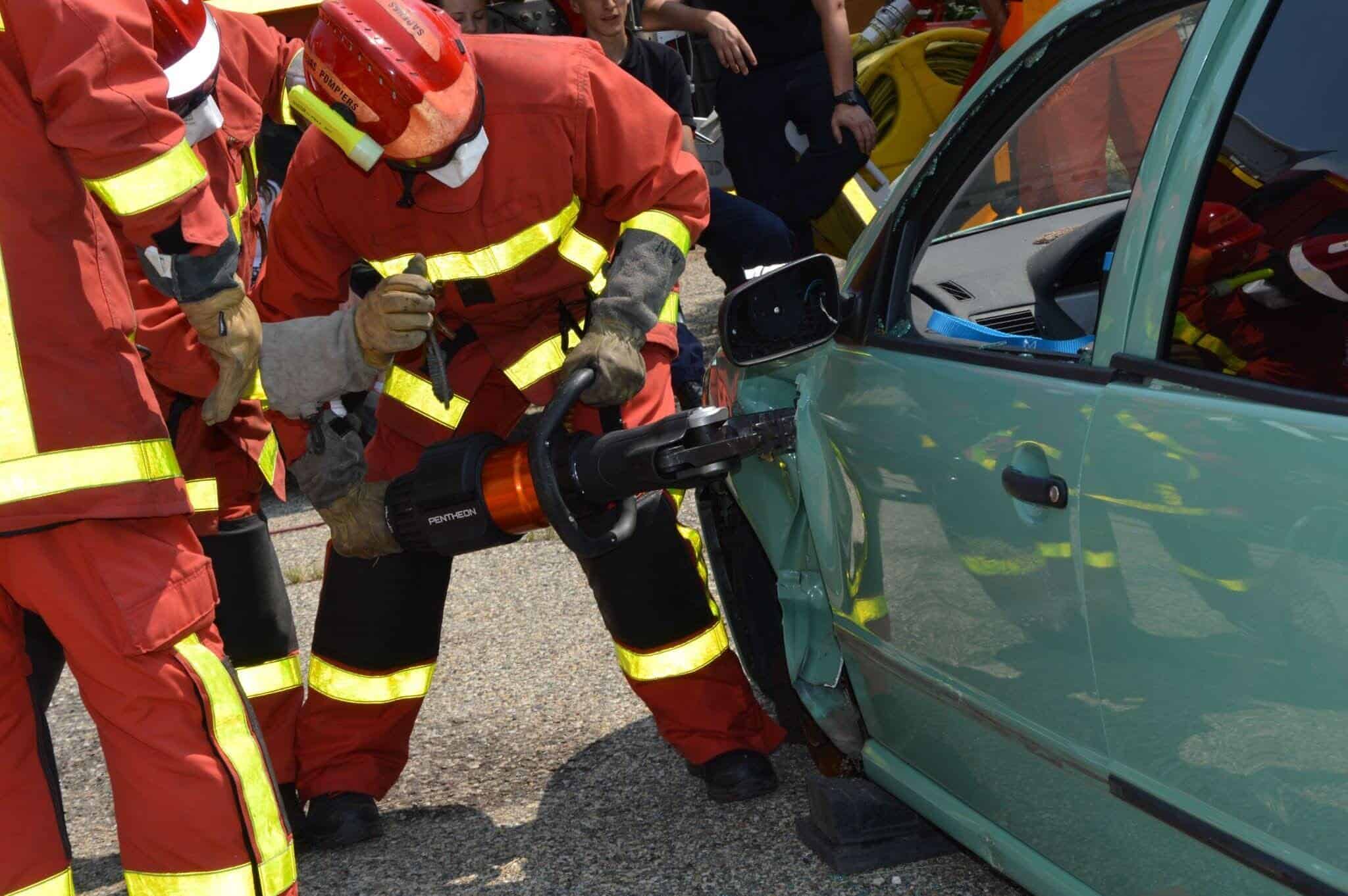 Firefighters are using a tool to open the door of a car that was in a crash.