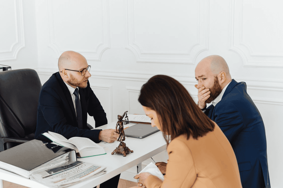 Man and woman looking sad while consulting with a lawyer